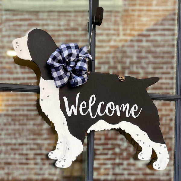 three spoiled dogs customizable springer spaniel welcome door hanger with a navy and white buffalo plaid bow hanging on a front door