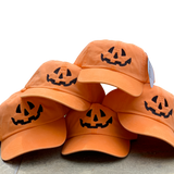 five orange baseball caps with a jack-o-lantern face embroidered in black