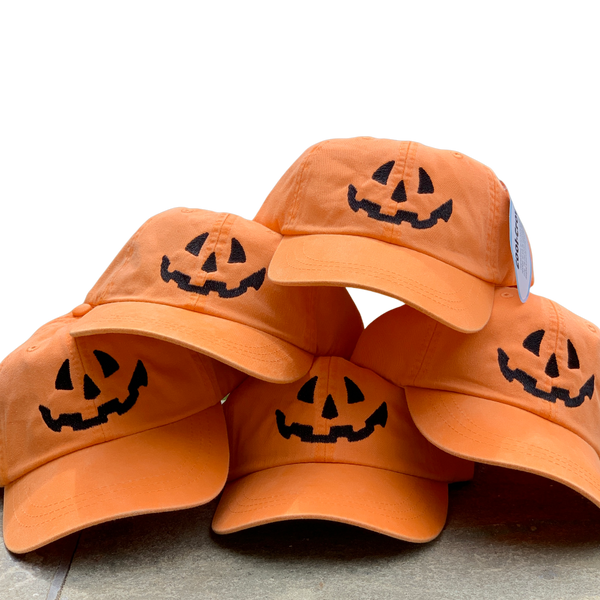 five orange baseball caps with a jack-o-lantern face embroidered in black