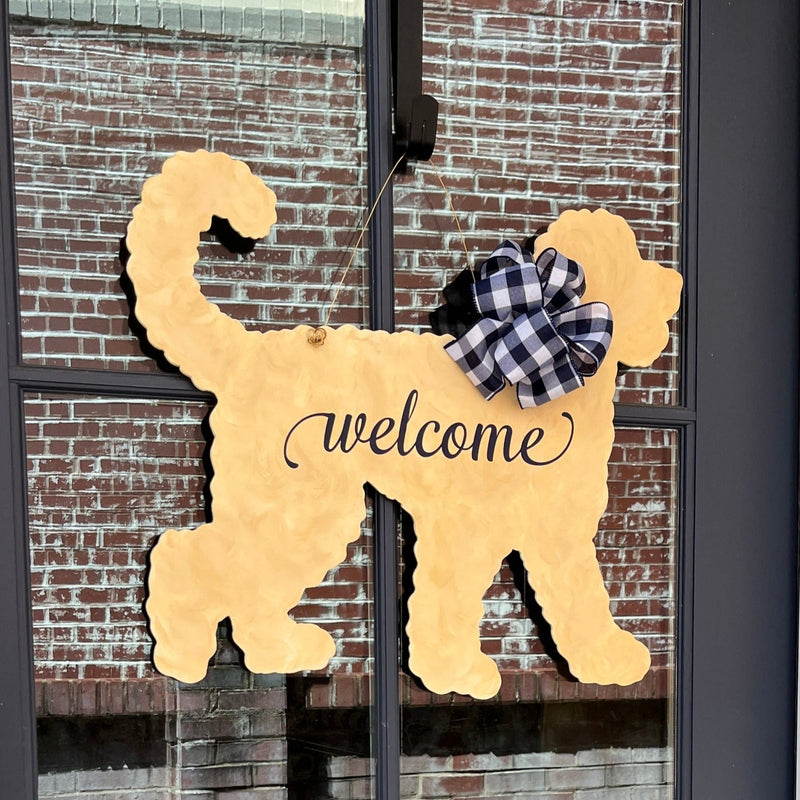 three spoiled dogs customizable goldendoodle doodle welcome door hanger with a navy buffalo plaid bow hanging on a front door