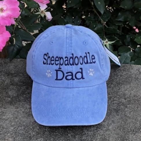 three spoiled dogs blue baseball cap with sheepadoodle dad embroidered in navy thread with two paw prints